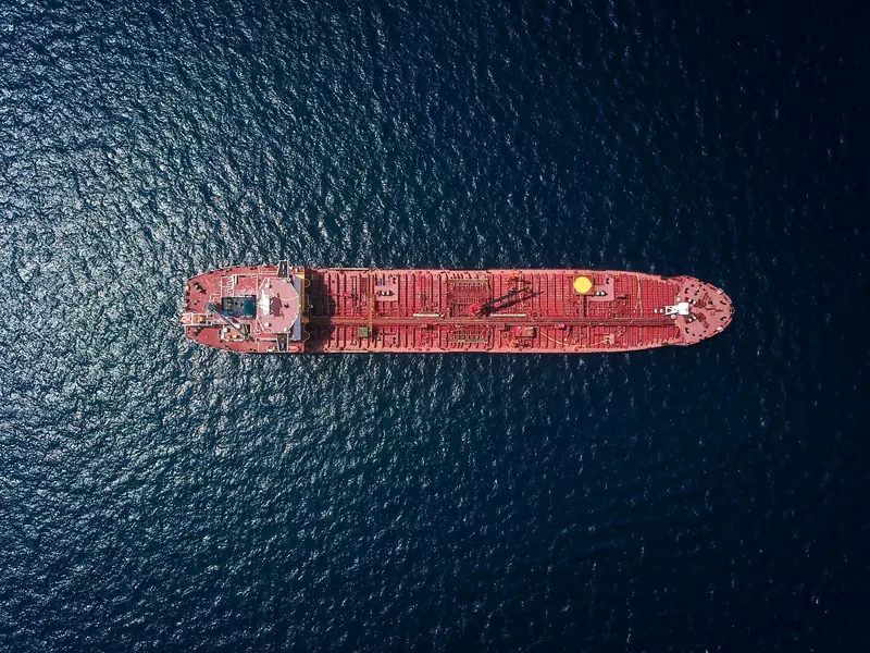 A tanker at anchor on dark water, seen from directly above